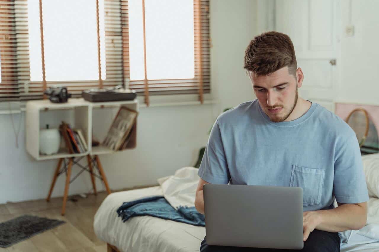 man sit on bed with computer